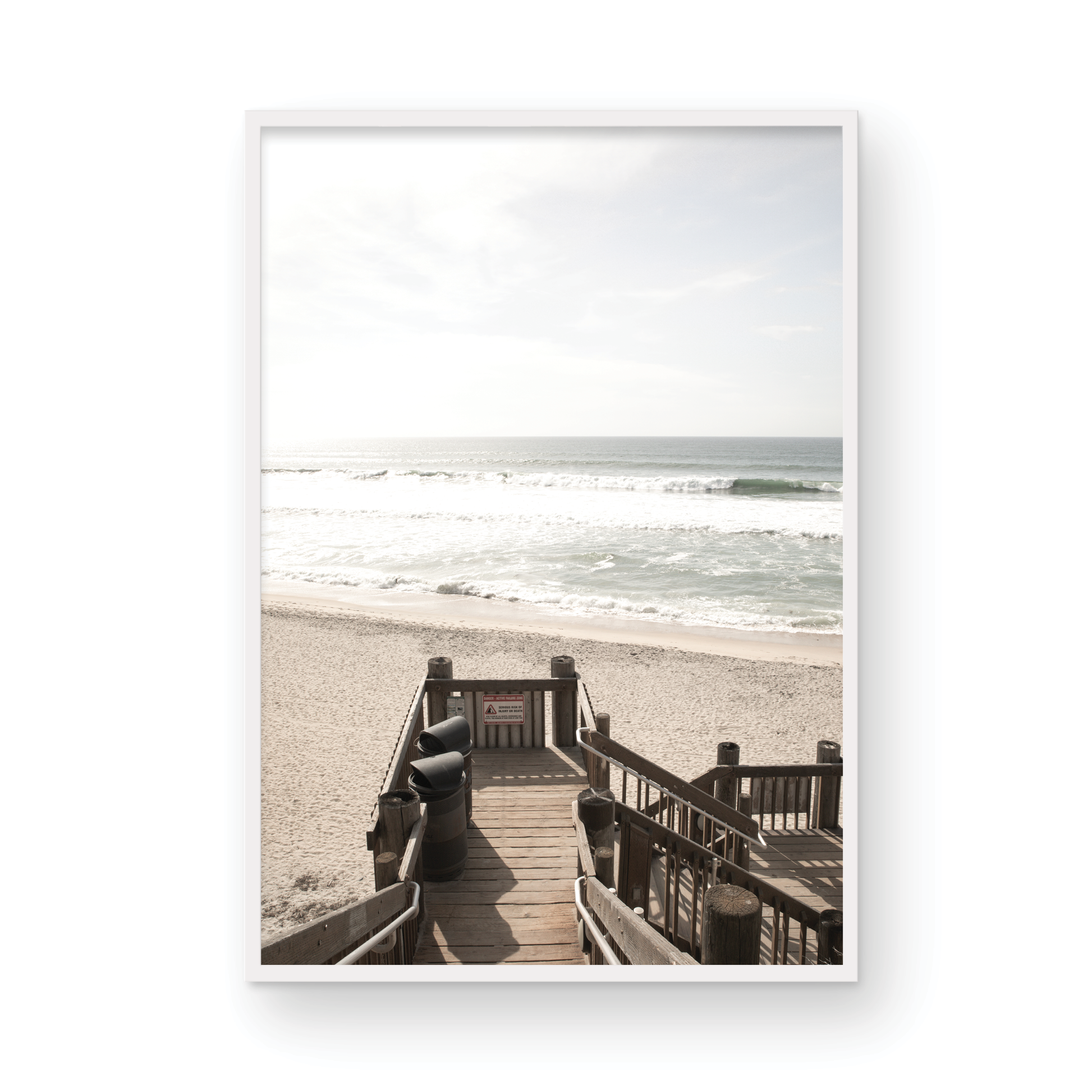 Vertical coastal wall print featuring a stairway leading down to a beach, overlooking an ocean view. Photograph in minimalist mock up.