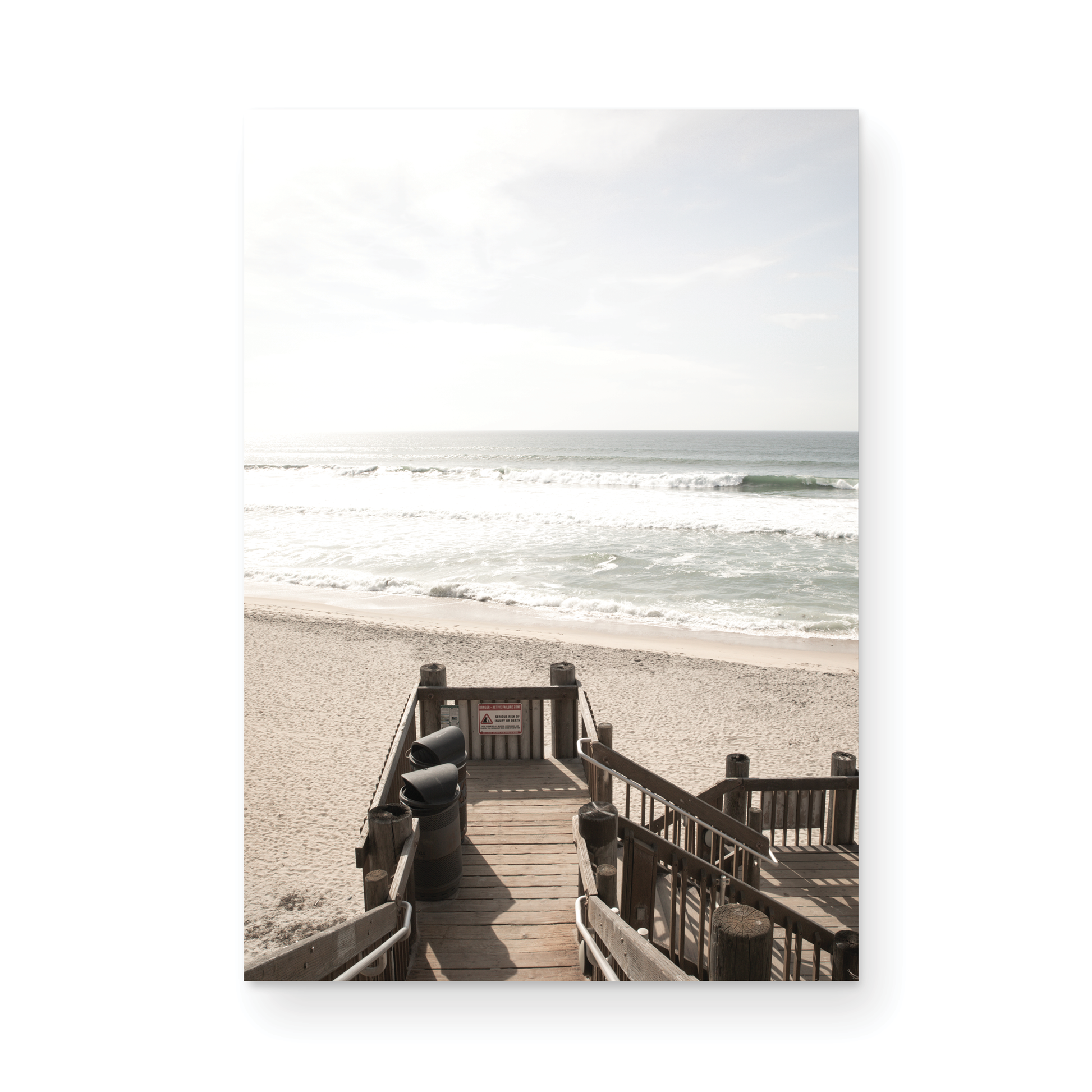 Vertical coastal wall print featuring a stairway leading down to a beach, overlooking an ocean view. Photograph in minimalist mock up.