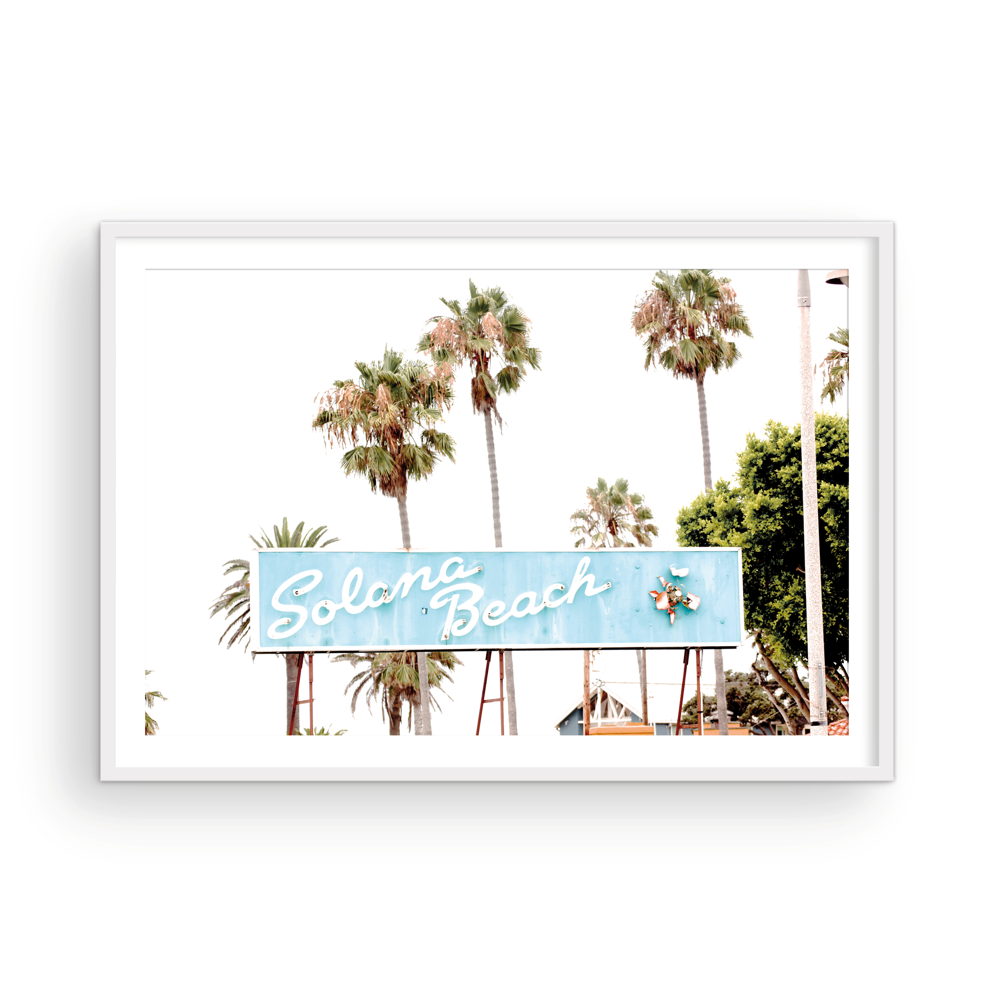 Colorful travel photography capturing the iconic 'Solana Beach' sign, a quintessential piece of Surf Signs San Diego art. The retro light blue sign, adorned with white cursive script and a unique steer head logo, is set against a backdrop of towering palm trees and a bright, hazy California sky. This Southern California surf beach sign evokes strong summer vibes and is perfect for coastal decor. Photograph in minimalist framed mock up.