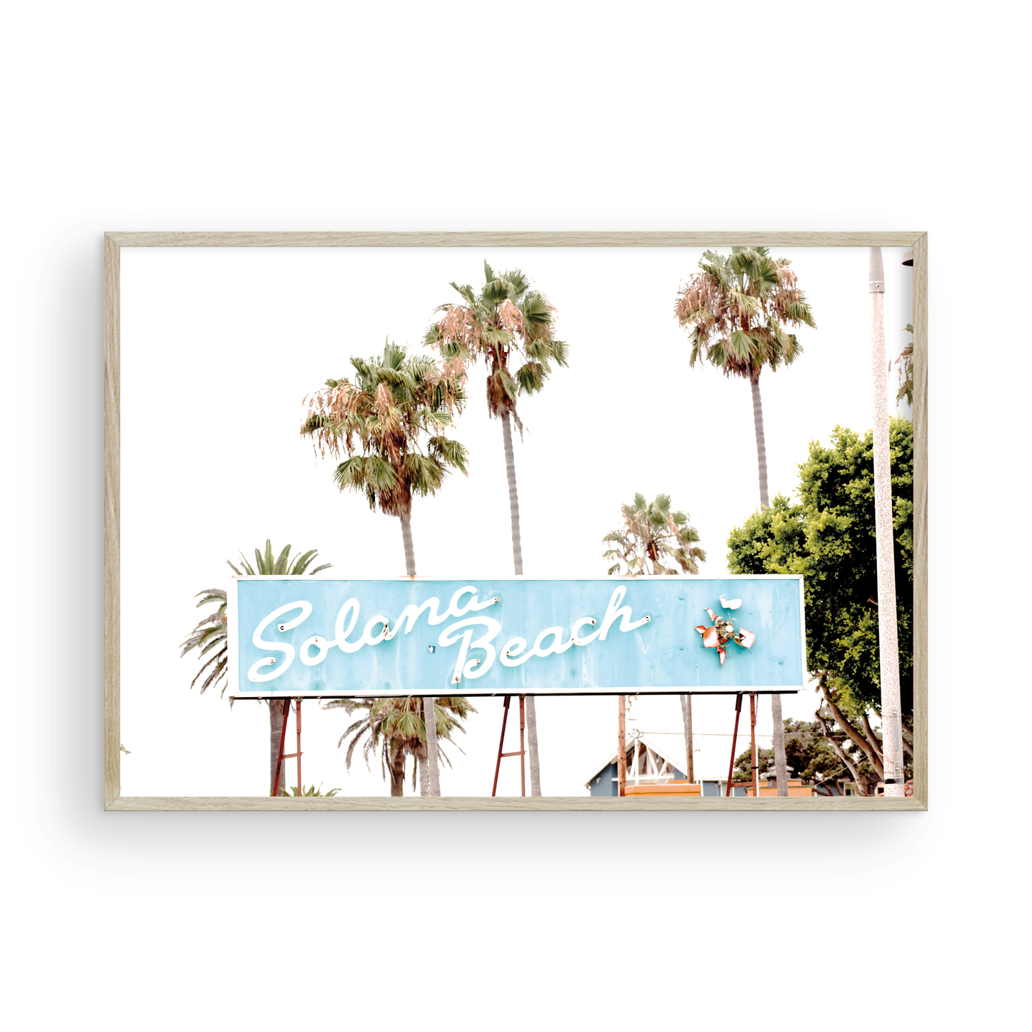 Colorful travel photography capturing the iconic 'Solana Beach' sign, a quintessential piece of Surf Signs San Diego art. The retro light blue sign, adorned with white cursive script and a unique steer head logo, is set against a backdrop of towering palm trees and a bright, hazy California sky. This Southern California surf beach sign evokes strong summer vibes and is perfect for coastal decor. Photograph in minimalist framed mock up.