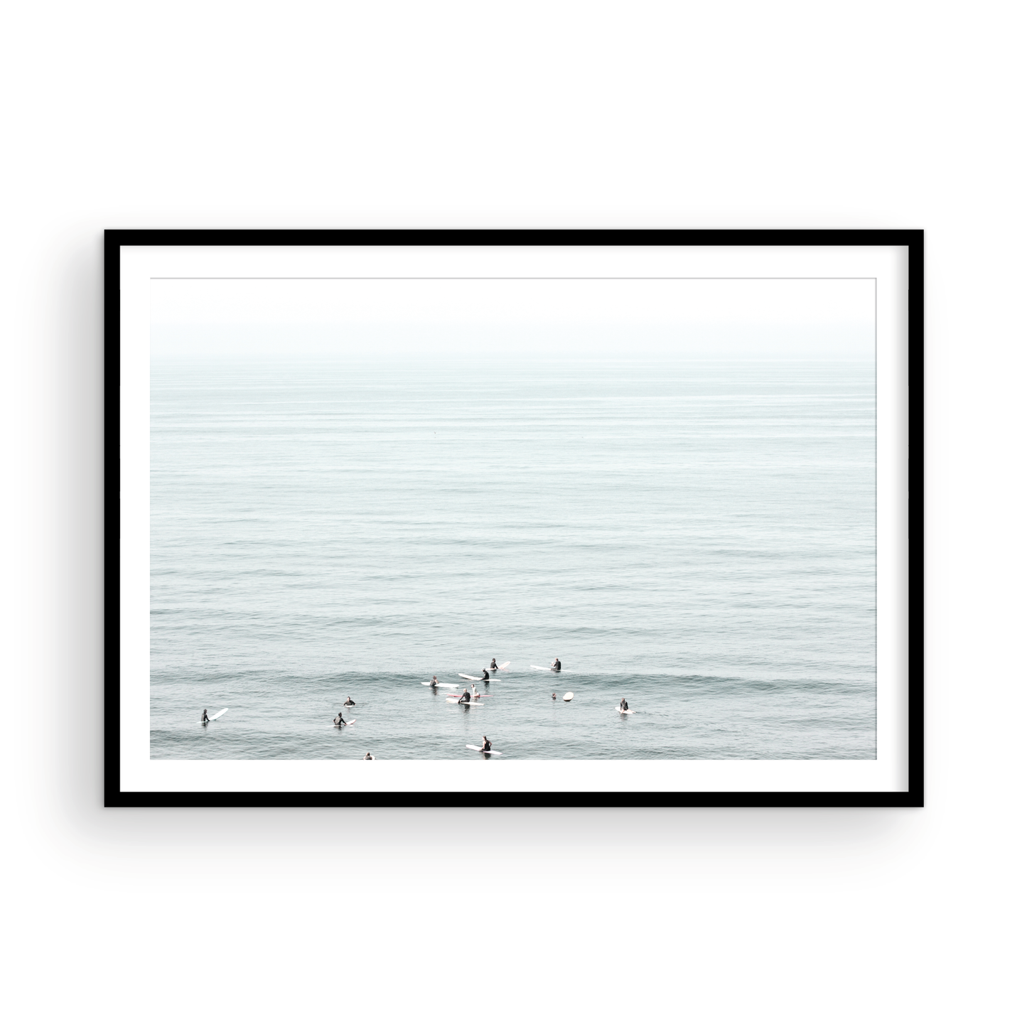 Horizontal surf art showing multiple surfers waiting in the calm ocean water for waves, with a hazy Southern California coastline in the distance. This minimalist surf print captures authentic surf vibes. Photograph in minimalist mock up.