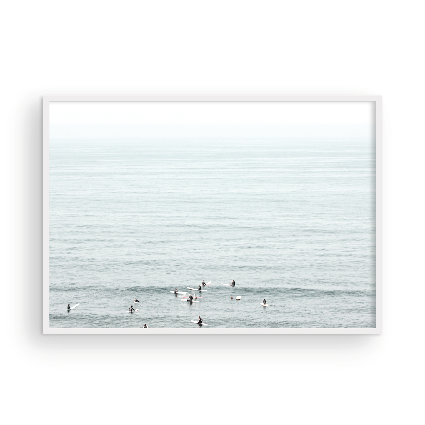 Horizontal surf art showing multiple surfers waiting in the calm ocean water for waves, with a hazy Southern California coastline in the distance. This minimalist surf print captures authentic surf vibes. Photograph in minimalist mock up.