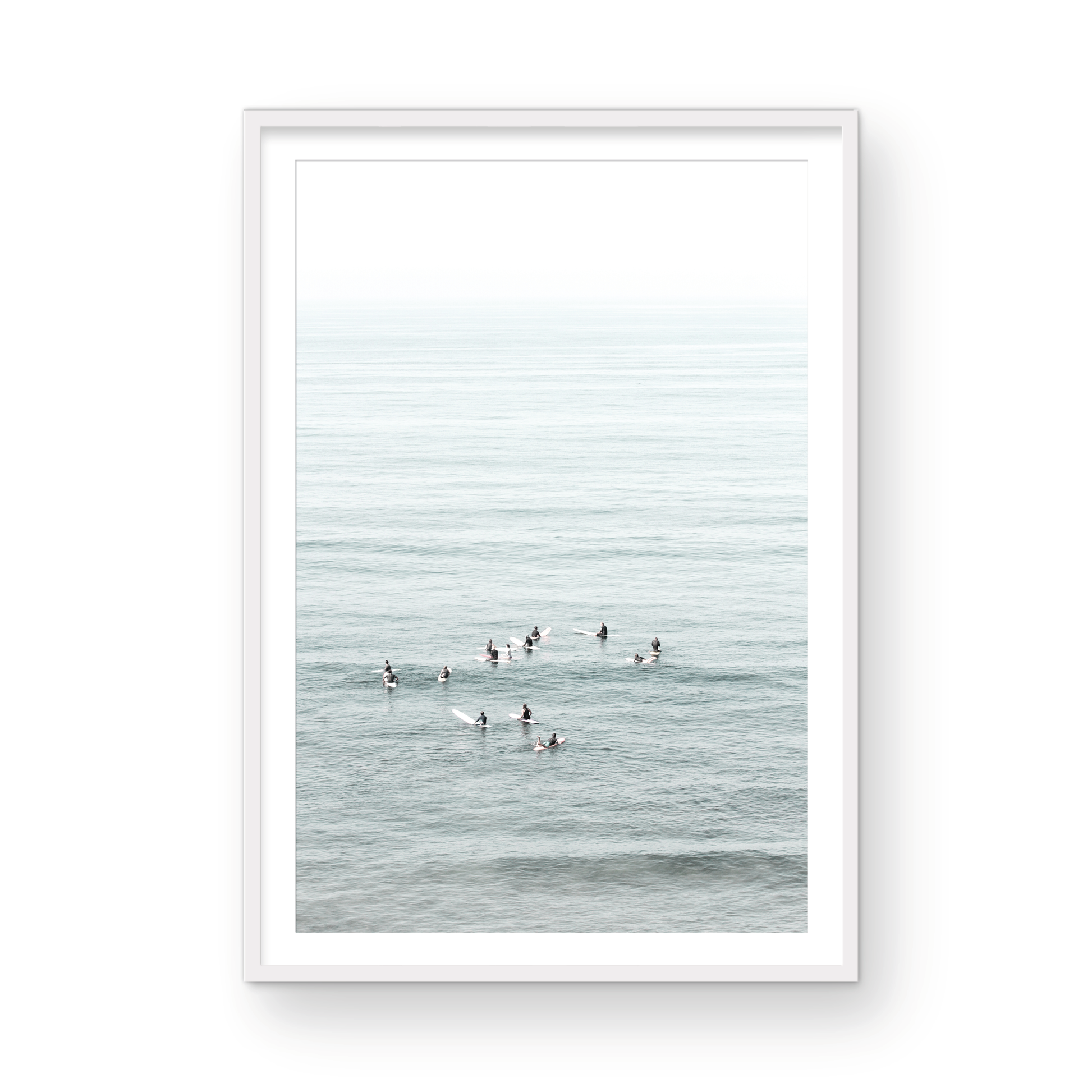 Vertical surf art showing multiple surfers waiting in the calm ocean water for waves, with a hazy Southern California coastline in the distance. This minimalist surf print captures authentic surf vibes. Photograph in minimalist mock up.