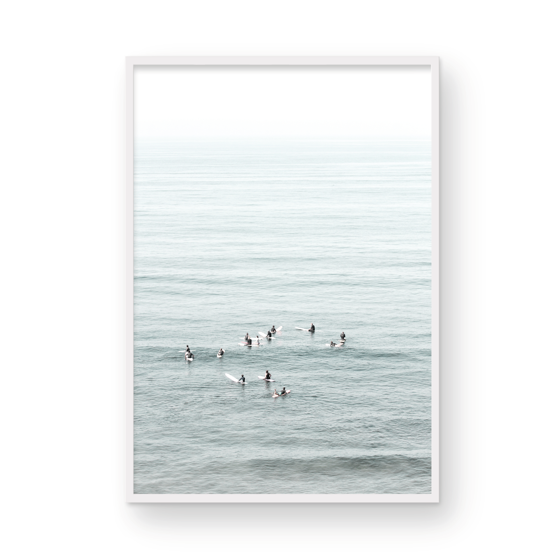 Vertical surf art showing multiple surfers waiting in the calm ocean water for waves, with a hazy Southern California coastline in the distance. This minimalist surf print captures authentic surf vibes. Photograph in minimalist mock up.
