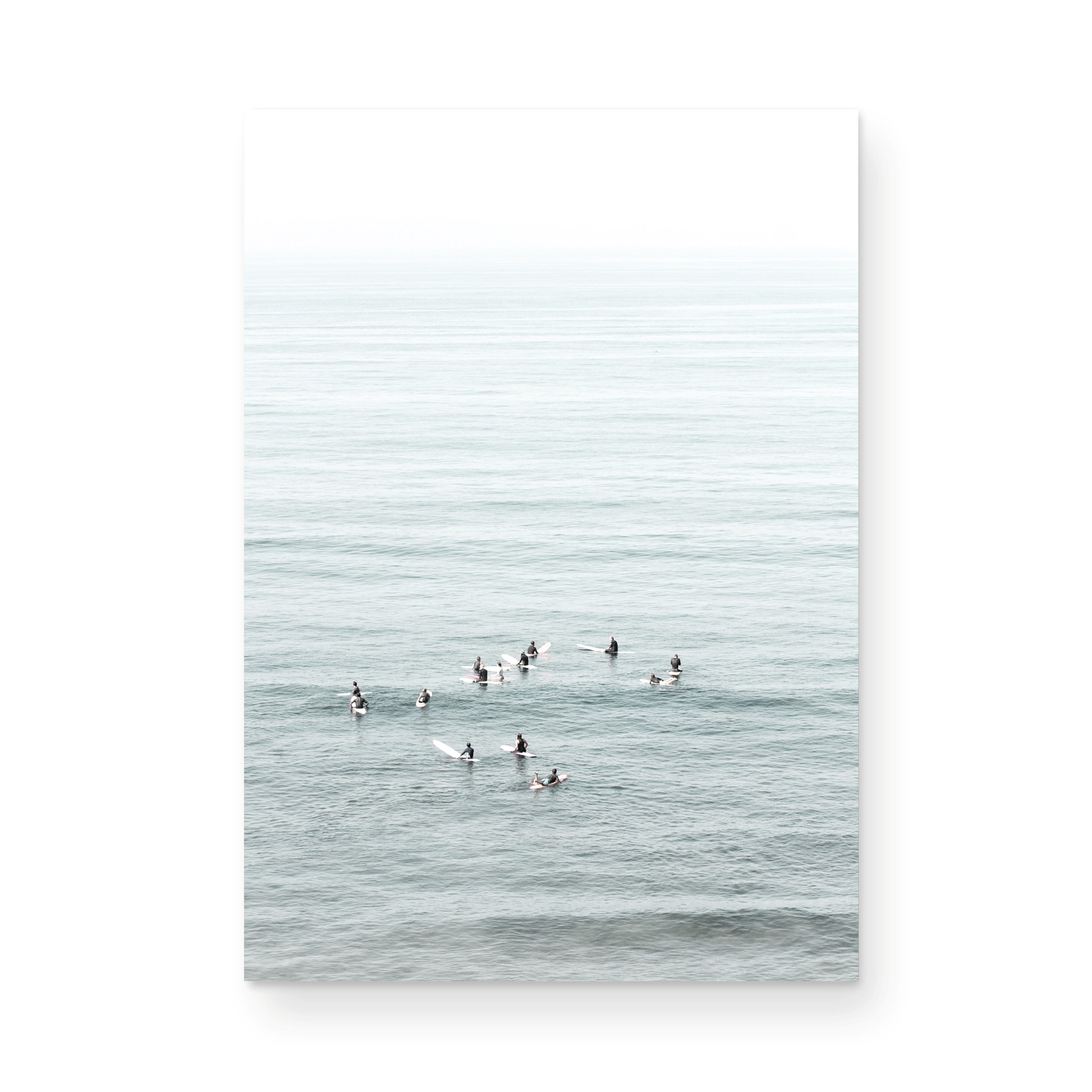 Vertical surf art showing multiple surfers waiting in the calm ocean water for waves, with a hazy Southern California coastline in the distance. This minimalist surf print captures authentic surf vibes. Photograph in minimalist mock up.