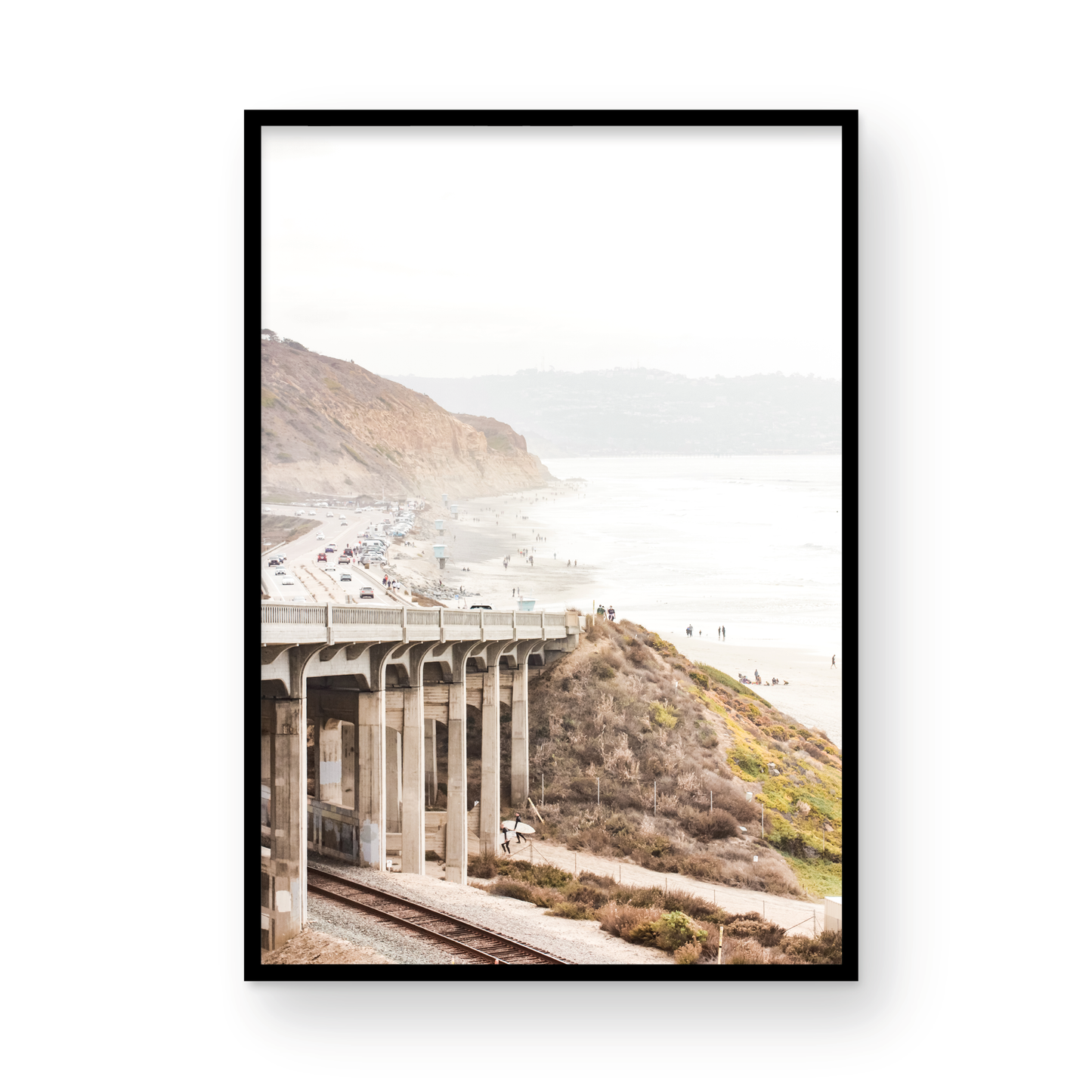 Captivating Torrey Pines San Diego coast scene, presented as vertical beach art. This piece of travel photography features a prominent bridge extending over a wide sandy beach with calm ocean waves. A coastal road winds along the base of rugged cliffs, with a lone coastal palm tree adding a touch of tropical essence to this Southern California seascape print. Photograph in minimalist mock up