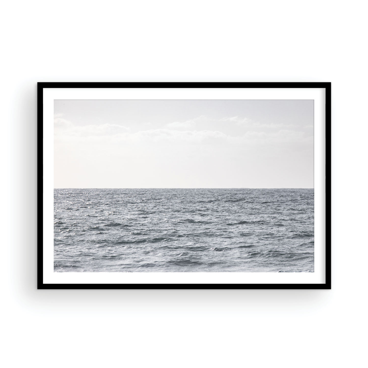 Minimalist ocean print of gentle ocean waves rolling at Moonlight Beach, San Diego, under a bright, soft sky. This calm beach print provides a serene seascape. Photograph in minimalist mock up
