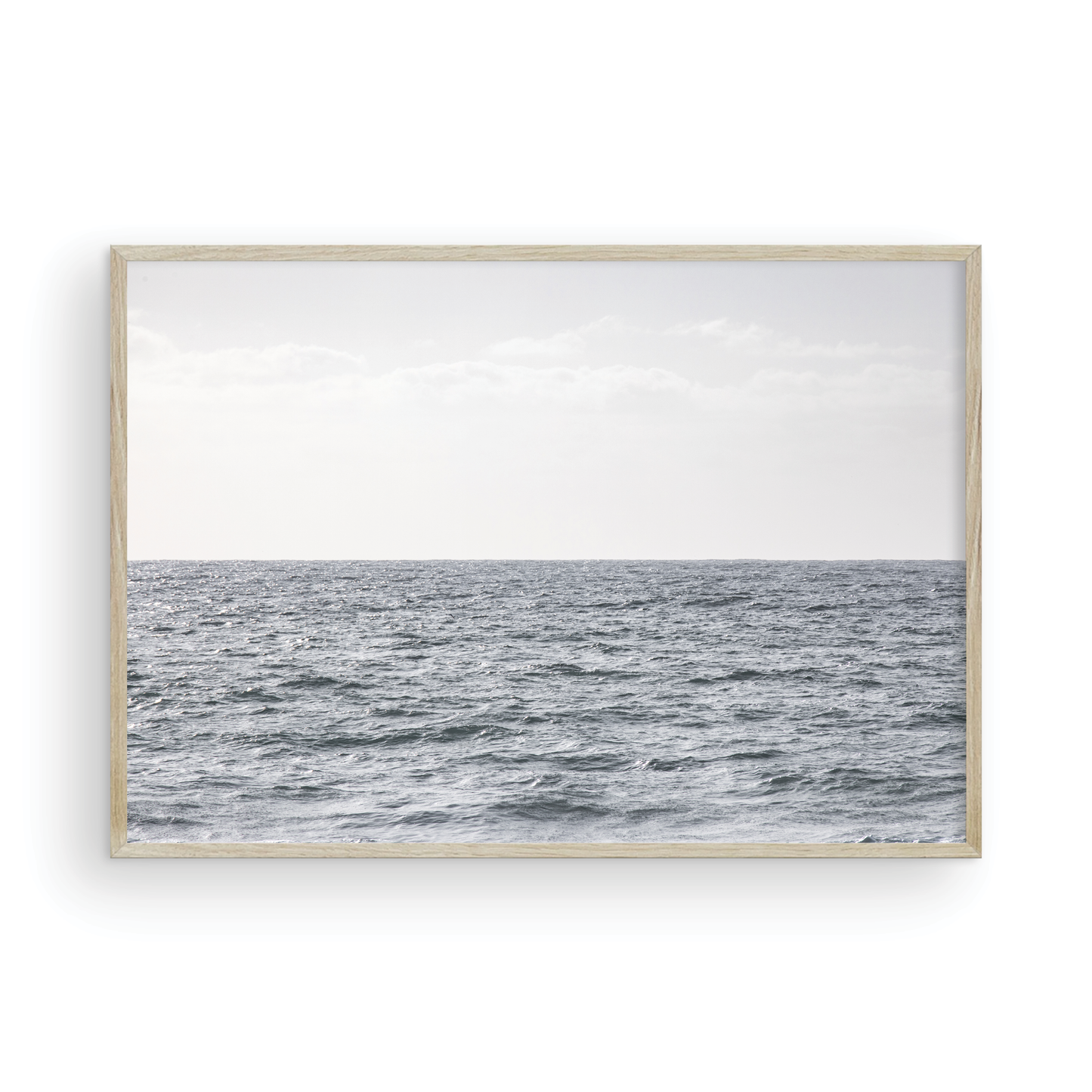 Minimalist ocean print of gentle ocean waves rolling at Moonlight Beach, San Diego, under a bright, soft sky. This calm beach print provides a serene seascape. Photograph in minimalist mock up