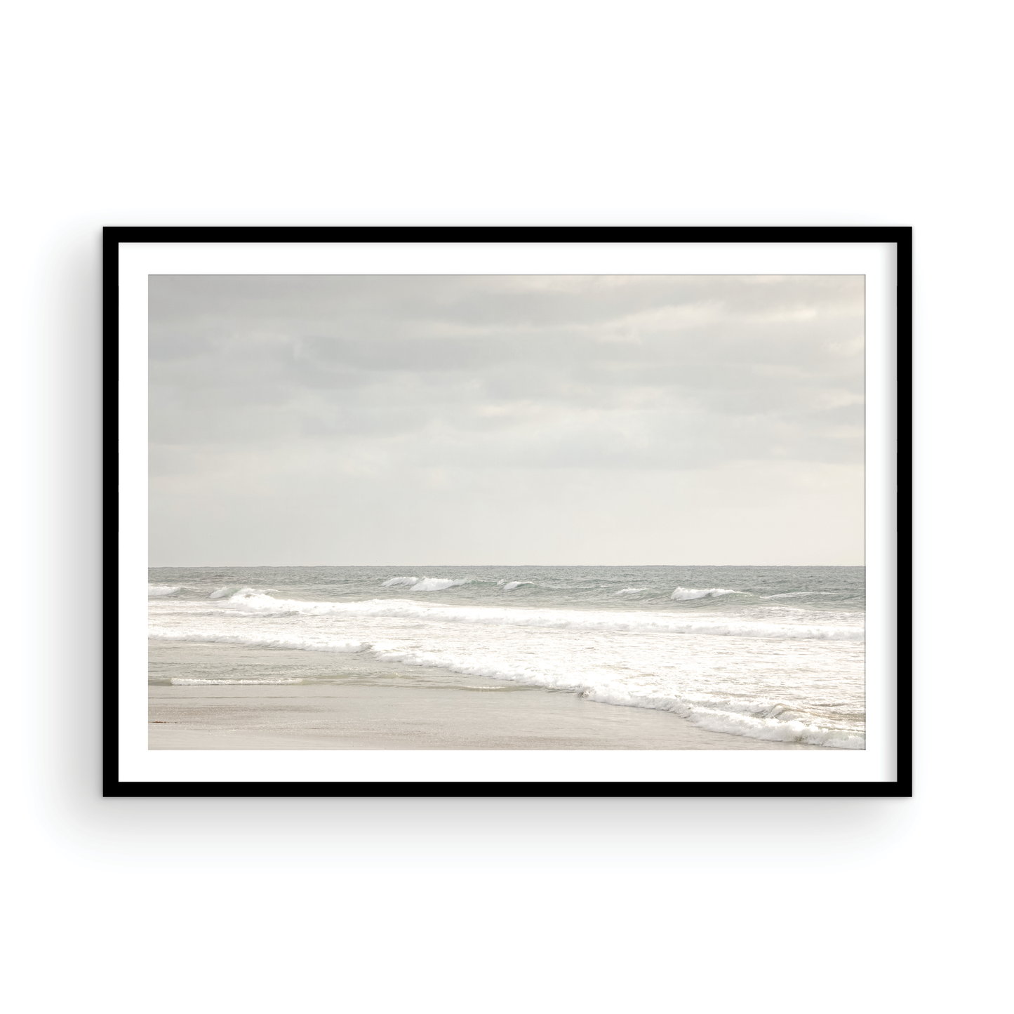 Horizontal minimalist ocean print of gentle ocean waves rolling onto a sandy shoreline at Moonlight Beach, San Diego, under a bright, soft sky. This calm beach print provides a serene seascape. Photograph in minimalist mock up.