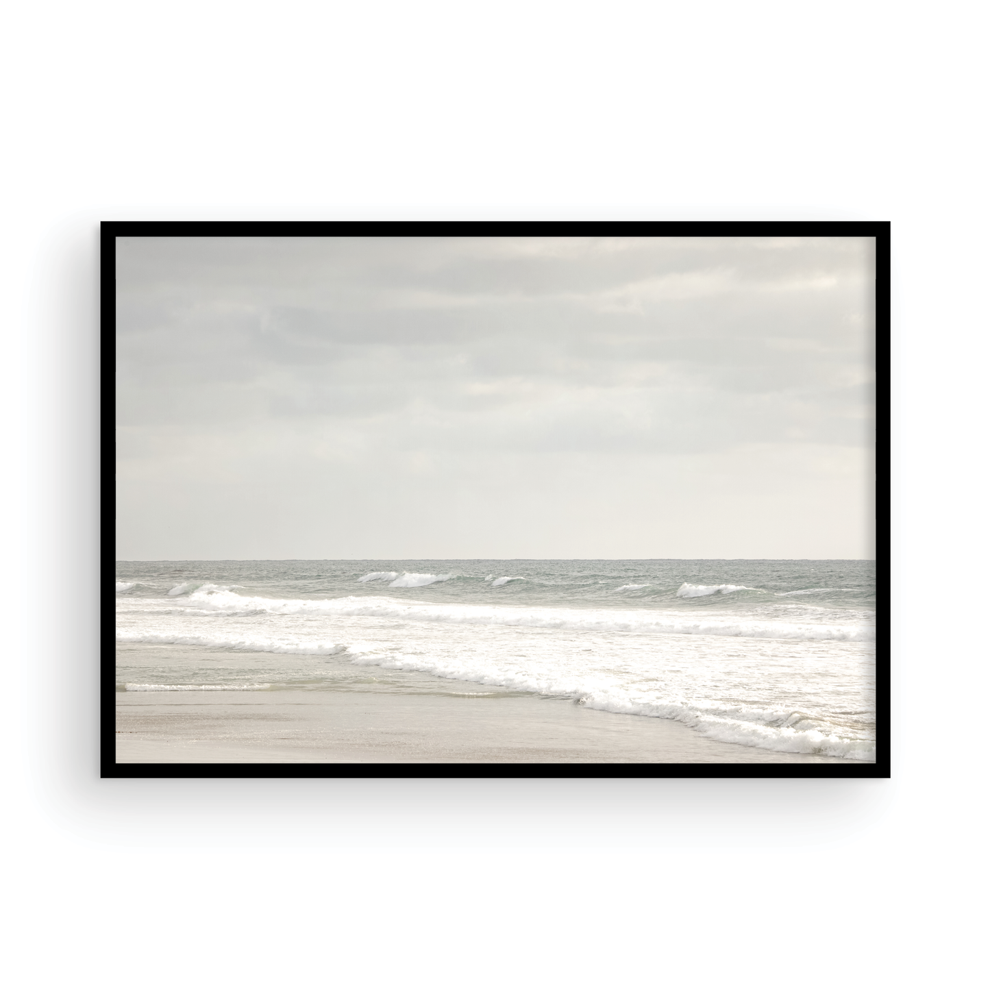 Horizontal minimalist ocean print of gentle ocean waves rolling onto a sandy shoreline at Moonlight Beach, San Diego, under a bright, soft sky. This calm beach print provides a serene seascape. Photograph in minimalist mock up.
