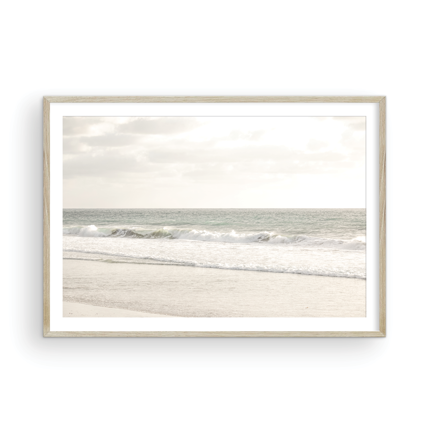 Minimalist ocean print of gentle ocean waves rolling onto a sandy shoreline at Moonlight Beach, San Diego, under a bright, soft sky. This calm beach print provides a serene seascape. Photograph in minimalist mock up.