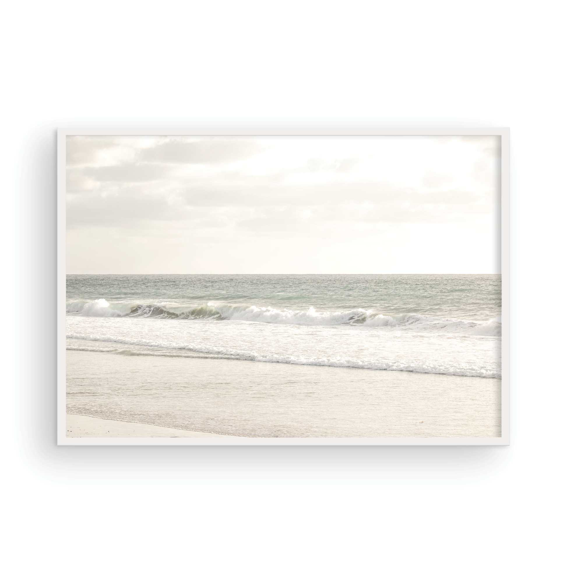 Minimalist ocean print of gentle ocean waves rolling onto a sandy shoreline at Moonlight Beach, San Diego, under a bright, soft sky. This calm beach print provides a serene seascape. Photograph in minimalist mock up.