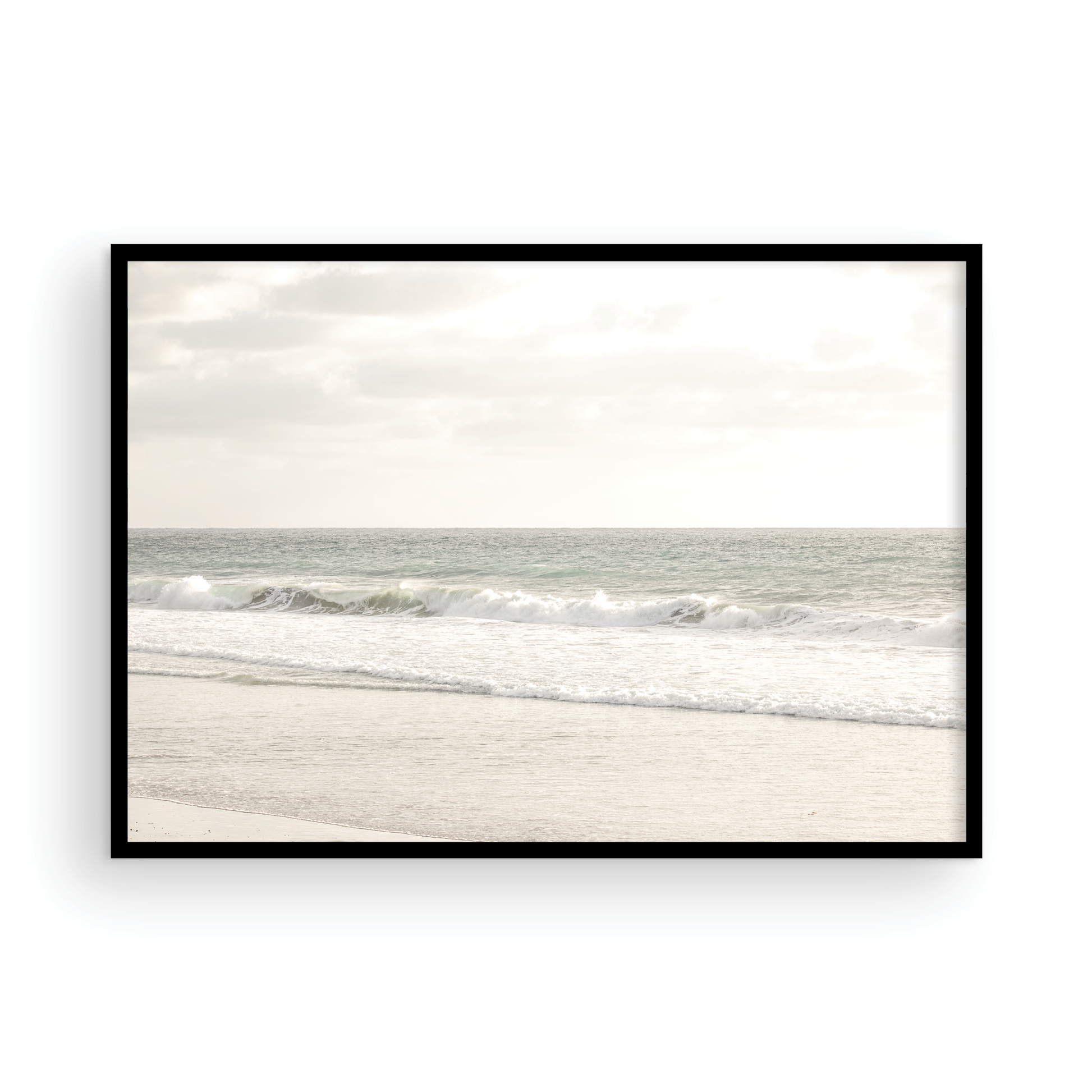 Minimalist ocean print of gentle ocean waves rolling onto a sandy shoreline at Moonlight Beach, San Diego, under a bright, soft sky. This calm beach print provides a serene seascape. Photograph in minimalist mock up.