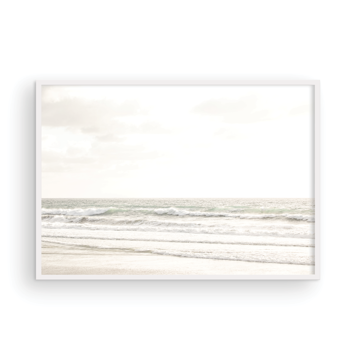 Horizontal minimalist ocean print of gentle ocean waves rolling onto a sandy shoreline at Moonlight Beach, San Diego, under a bright, soft sky. This calm beach print provides a serene seascape. Photograph in minimalist mock up.