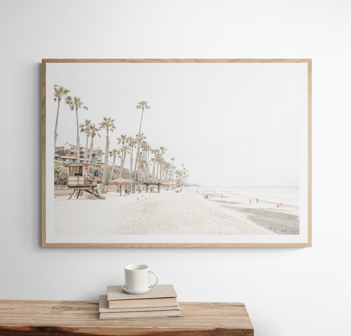 A wide landscape coastal photography view of San Clemente State Beach in Southern California, featuring a row of tall palm trees, a lifeguard tower, and people enjoying the calm beach. This horizontal image evokes Summer Vibes Wall Art and tropical beach print aesthetics. Photograph in minimalist mock up.