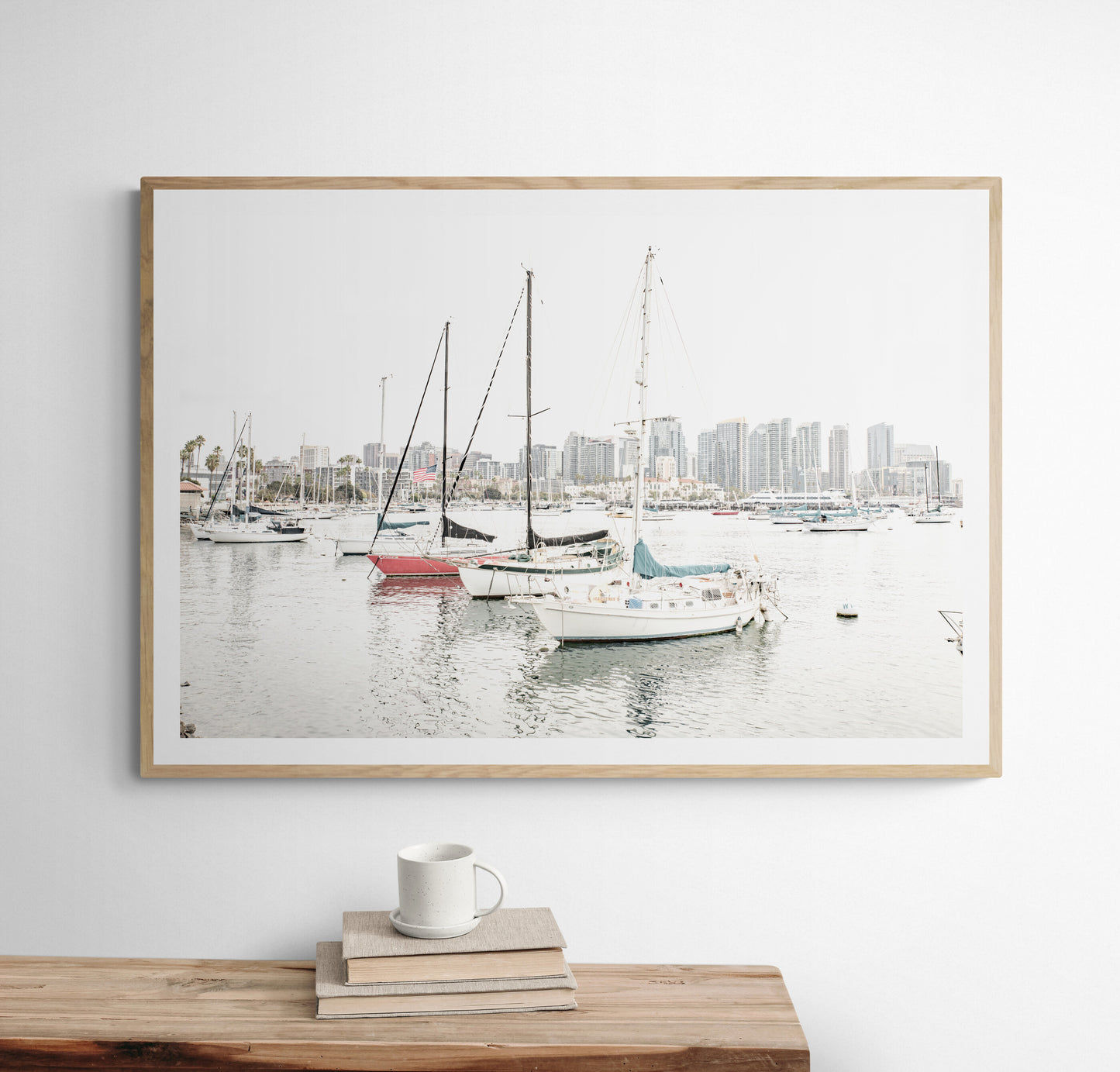 A horizontal San Diego print showcasing numerous sailboats in San Diego Harbor with the city skyline in the background. This modern coastal print embodies the Southern California coastal photography, perfect for a large beach wall art. Photograph in minimalist mock up.