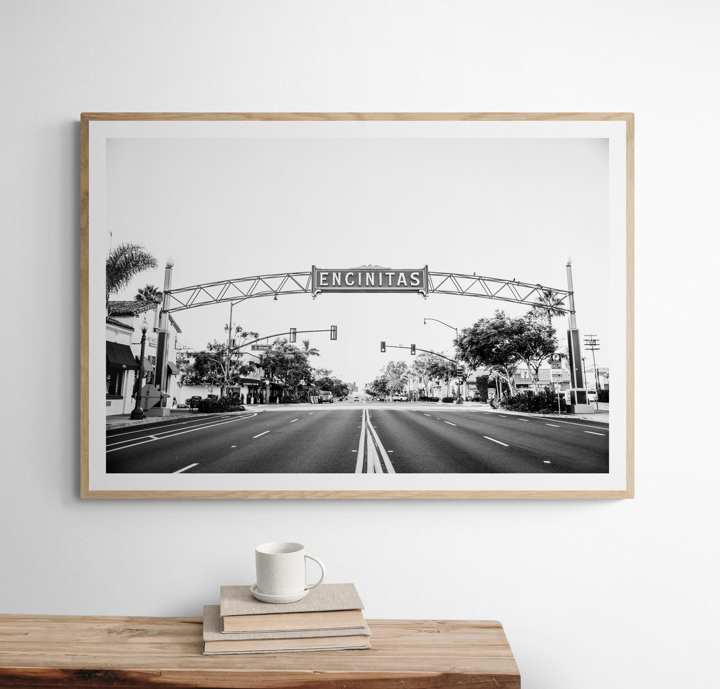 A black and white photograph of a street sign that reads 'Encinitas' with a background of a city street. Photograph in minimalist mock up.