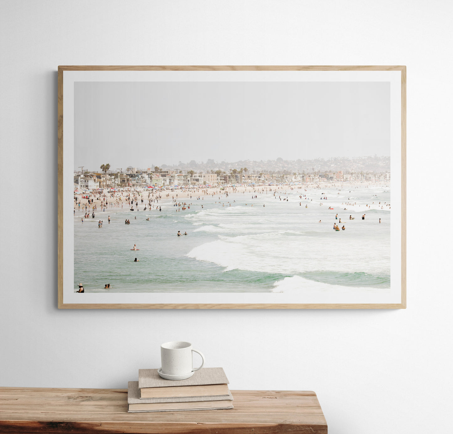 Landscape beach photography of a busy San Diego public beach with many people in the sand and ocean waves, a true summer vibes scene. Photograph in minimalist mock up.