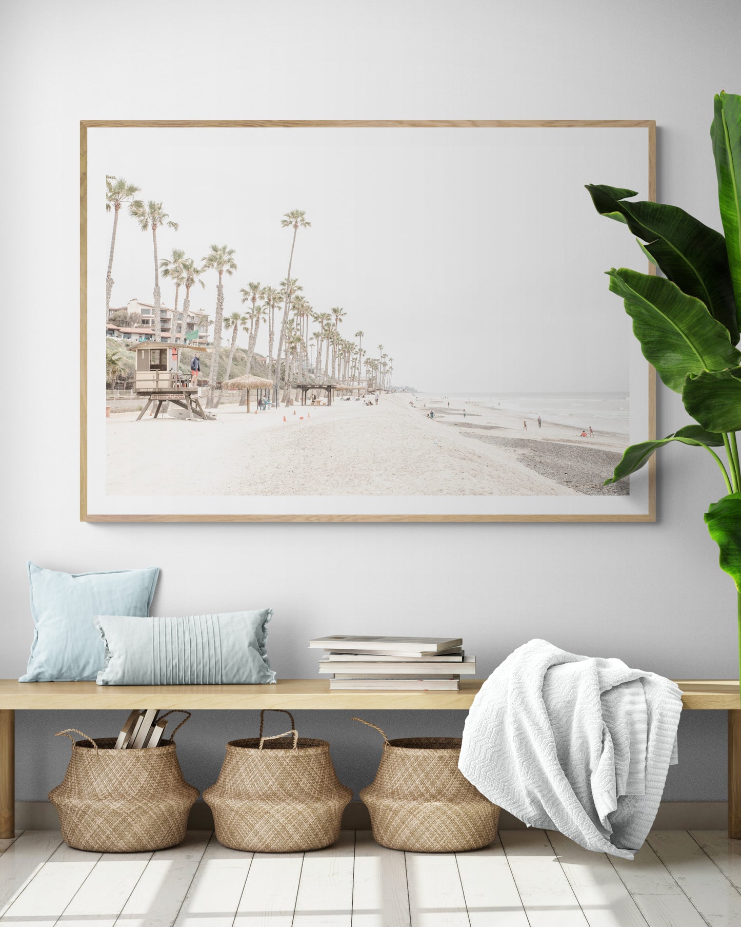 A wide landscape coastal photography view of San Clemente State Beach in Southern California, featuring a row of tall palm trees, a lifeguard tower, and people enjoying the calm beach. This horizontal image evokes Summer Vibes Wall Art and tropical beach print aesthetics. Photograph in minimalist mock up.