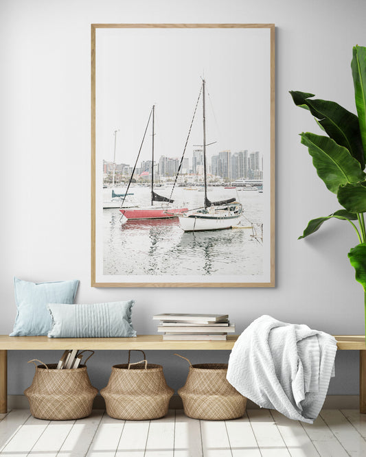A vertical San Diego print showcasing numerous sailboats in San Diego Harbor with the city skyline in the background. This modern coastal print embodies the Southern California coastal photography, perfect for a large beach wall art. Photograph in minimalist mock up.