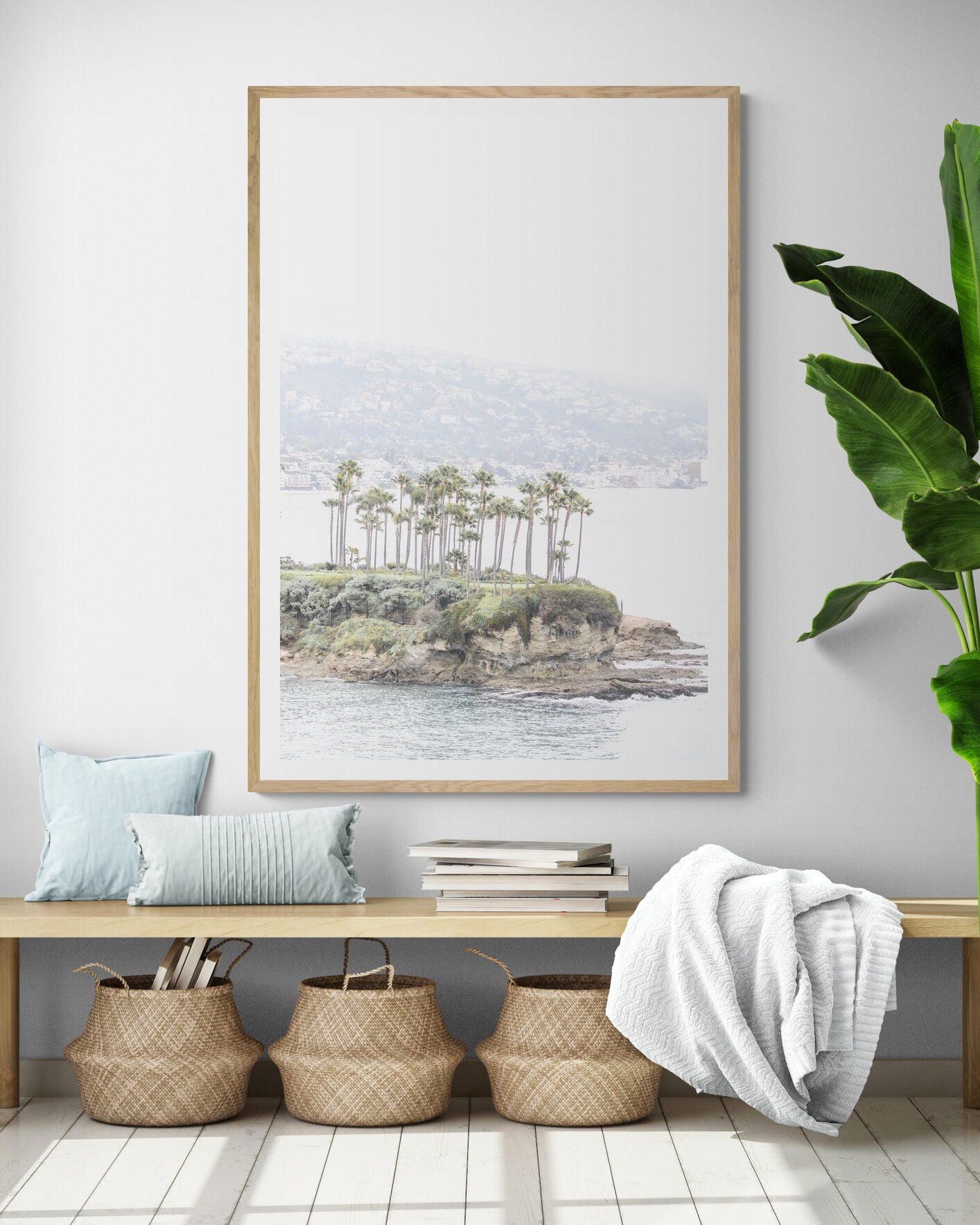 Vertical coastal photography of Laguna Beach, San Diego, featuring a fine art giclee print featuring palm trees on a small island in a body of water. Photograph in minimalist mock up.