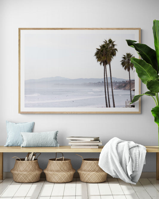 Landscape San Diego beach print showing a seascape with gentle ocean waves in the water and palm trees in the foreground. Photograph in minimalist mock up.