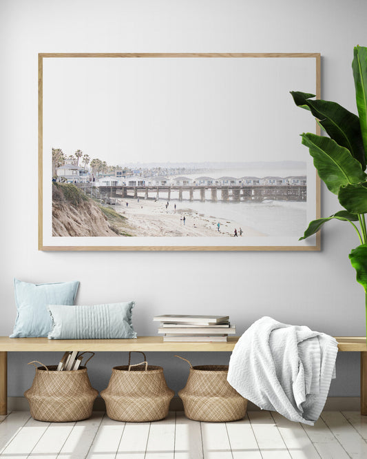 Landscape San Diego beach print of Pacific Beach's Crystal Pier, featuring its unique houses extending over the water, with people on the sandy shore. This iconic beach print is great for beach decor. Photograph in minimalist mock up.