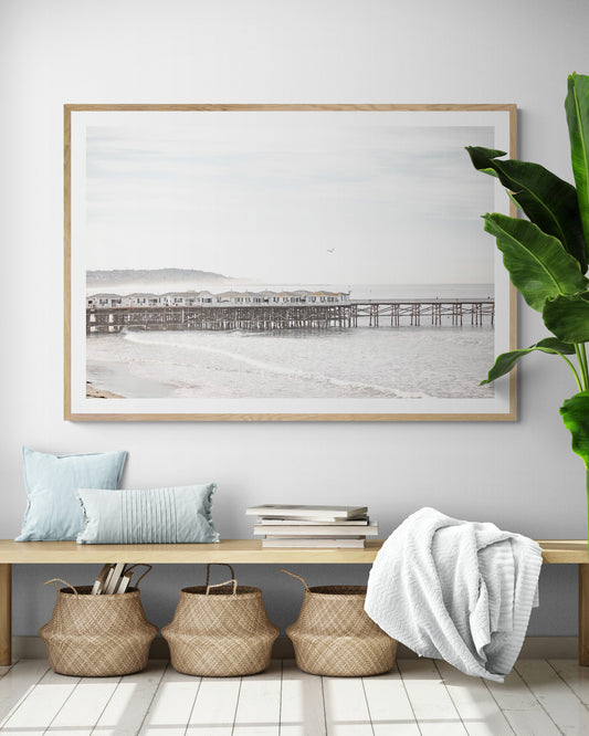 Landscape coastal photography of Crystal Pier in Pacific Beach, San Diego, extending into the calm ocean with gentle waves. Photograph in minimalist mock up