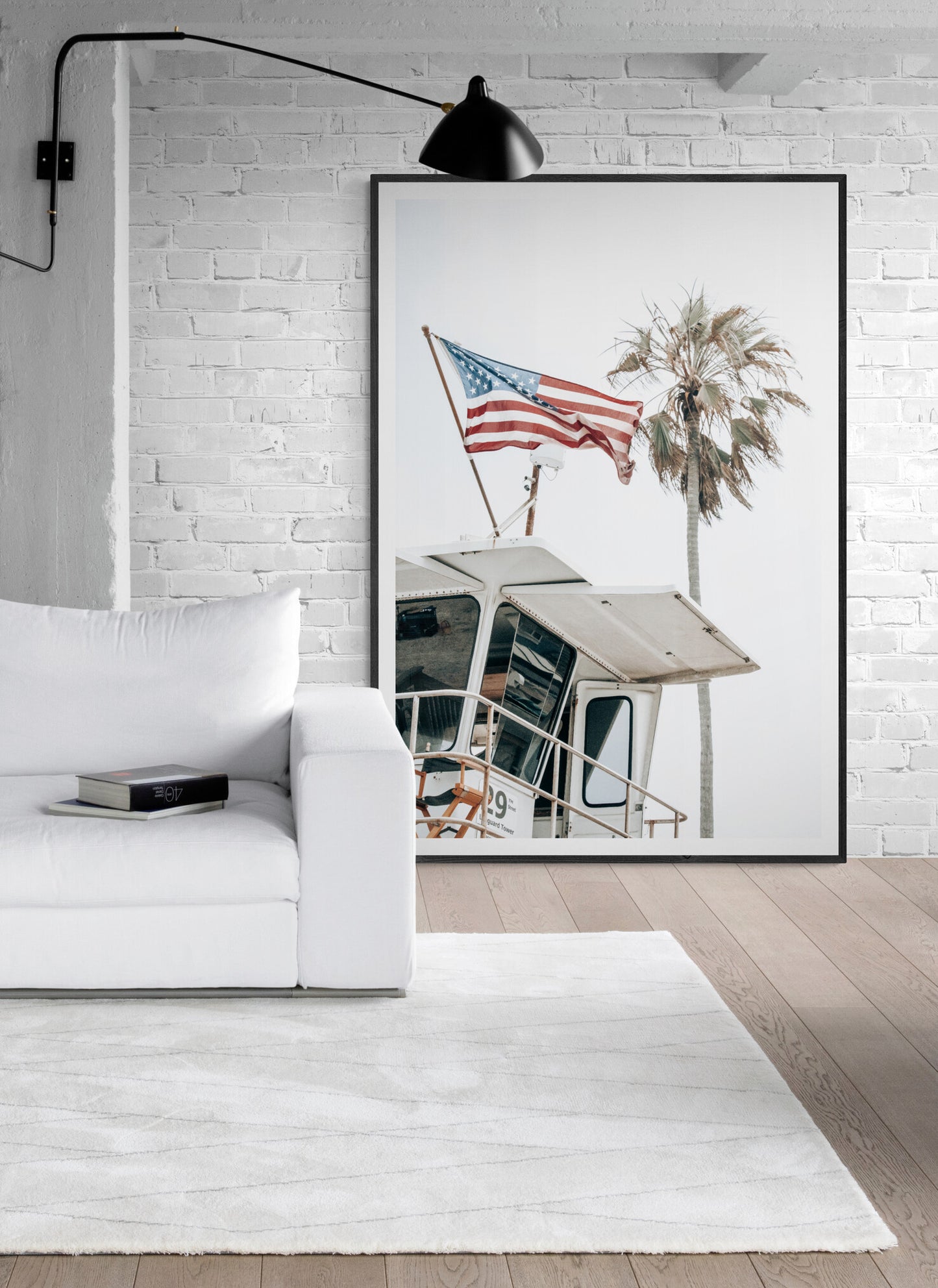 An American flag attached to a lifeguard tower with palm trees in the background, captured in California with a clear sky in the top half of the image. Photograph in minimalist mock up.
