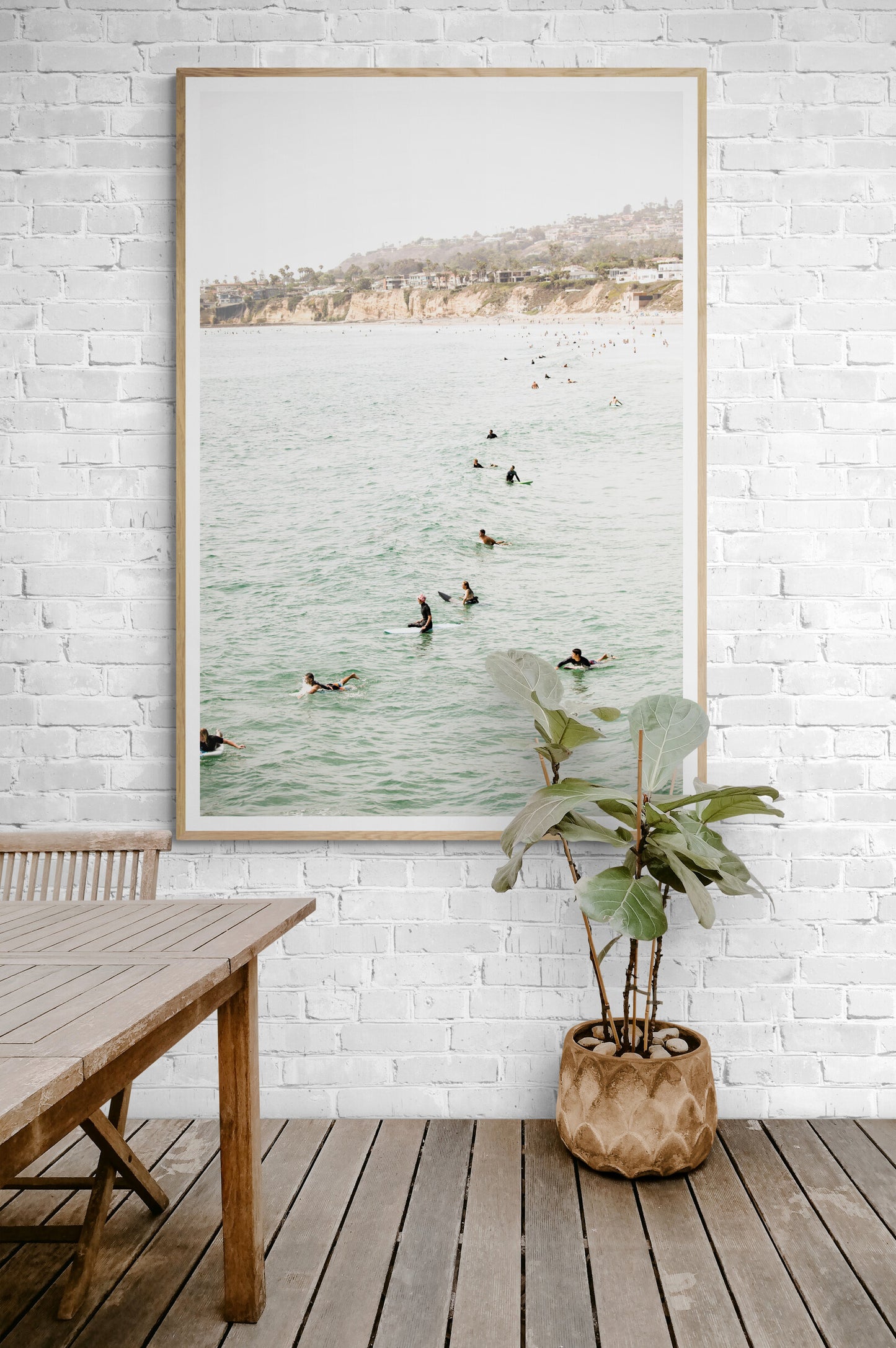 Vertical surf print showing several surfers paddling in the ocean at Pacific Beach, with a distant coastline. This image captures the surfing art of Southern California. Photograph in minimalist mock up.