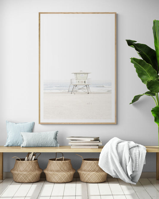A vertical beach art close-up of a pale lifeguard tower (16), with ocean waves in the distance, on a San Diego Beach. Photograph in minimalist mock up.