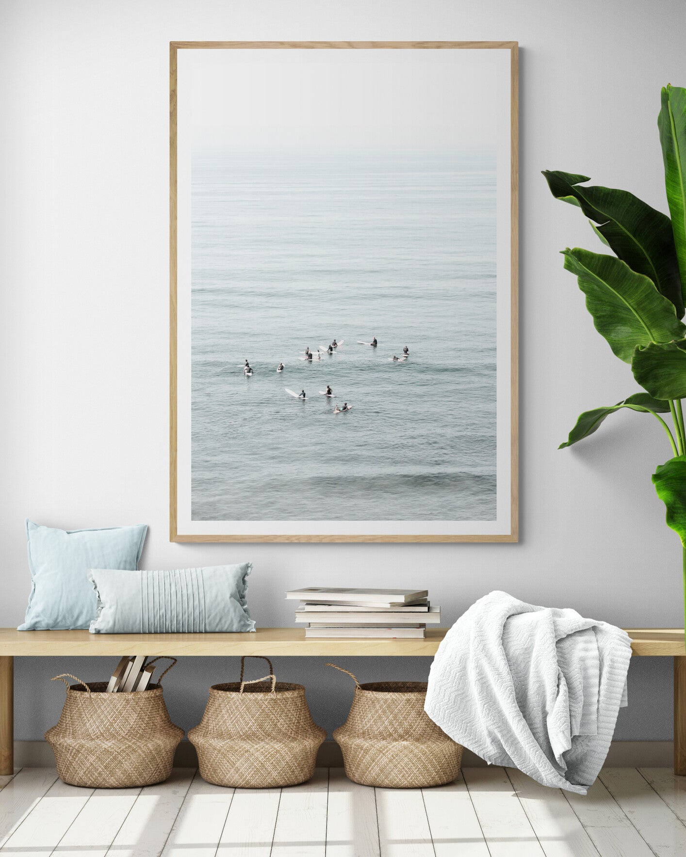 Vertical surf art showing multiple surfers waiting in the calm ocean water for waves, with a hazy Southern California coastline in the distance. This minimalist surf print captures authentic surf vibes. Photograph in minimalist mock up.