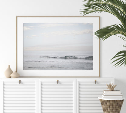 Horizontal minimalist ocean art with a close-up blue waves print of water, featuring subtle ripples and soft textures, ideal as a neutral ocean print, surfers in the waves. Photograph in minimalist mock up.