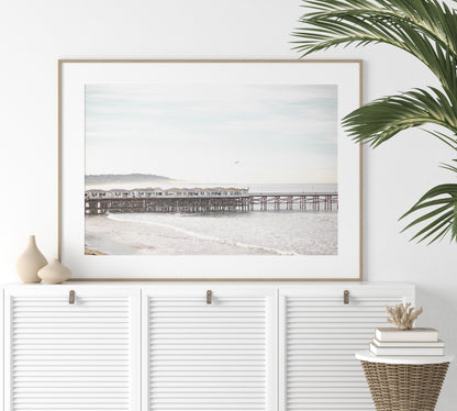 Landscape coastal photography of Crystal Pier in Pacific Beach, San Diego, extending into the calm ocean with gentle waves. Photograph in minimalist mock up