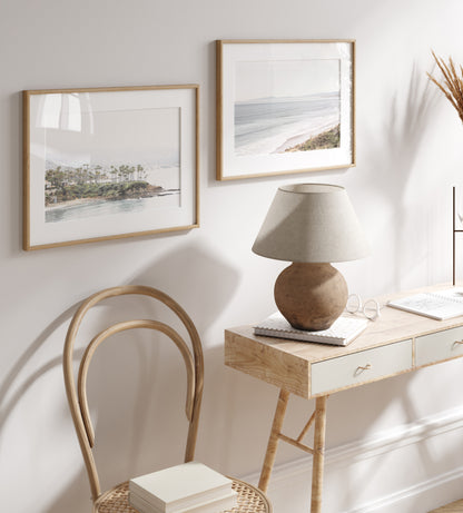 Horizontal coastal photography of Laguna Beach, San Diego, featuring a fine art giclee print featuring palm trees on a small island in a body of water. Photograph in minimalist mock up.