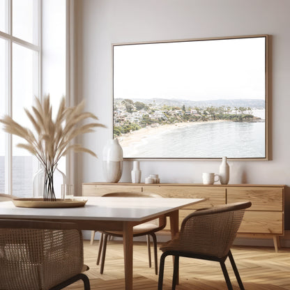Horizontal coastal photography featuring a beach scene with a calm ocean and beach homes lining the shoreline, located in Laguna California. Photograph in minimalist mock up.