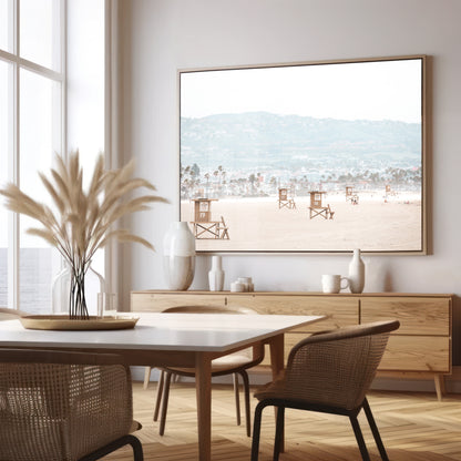 Landscape beach photography of Santa Monica State Beach with multiple lifeguard towers on the vast sandy expanse and hazy hills in the background. Photograph in minimalist mock up