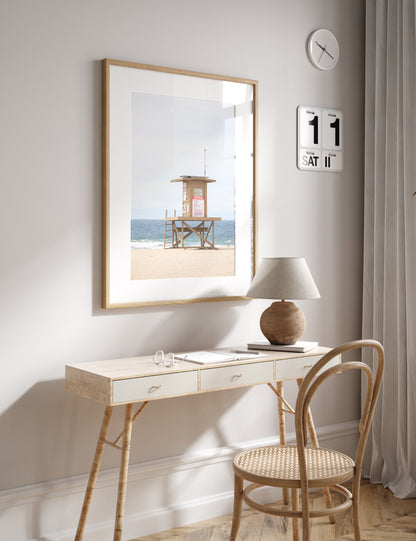 A wide landscape coastal photography view of Newport Beach in Southern California, featuring a lifeguard tower and walls on the beach. Photograph in minimalist mock up.