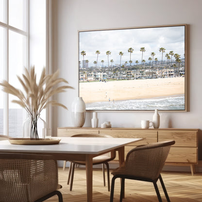 Landscape beach photography of Newport Beach, California, showing a wide sandy beach, a long line of tall palm trees, and coastal homes. Photograph in minimalist mock up.