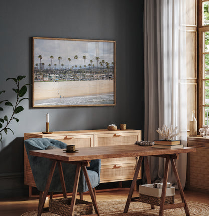 Landscape beach photography of Newport Beach, California, showing a wide sandy beach, a long line of tall palm trees, and coastal homes. Photograph in minimalist mock up.