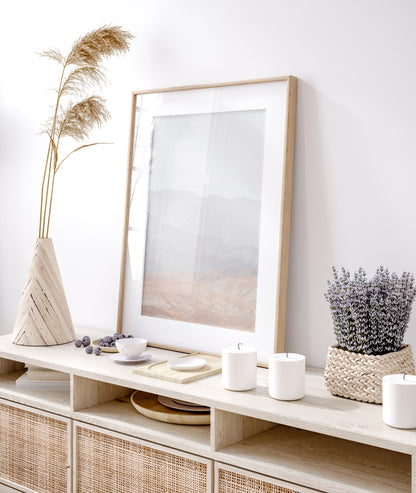 Minimalist art print of hazy mountains layered in soft tones, creating a calm ocean print aesthetic. This vertical minimalist art print can fit a neutral ocean print theme. Photograph in minimalist mock up.