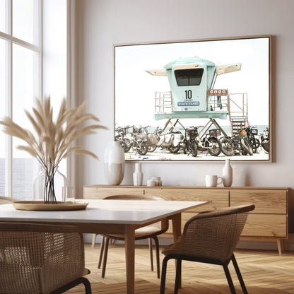 Captured in a horizontal San Diego print, a light blue Lifeguard Tower (number 10) stands prominently among numerous bicycles are parked nearby. Located in Seaside Beach, San Diego, California. Photograph in minimalist mock up.