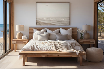 Minimalist ocean print featuring gentle ocean waves breaking on a sandy beach under a bright, hazy sky with a single bird in flight. A serene and neutral ocean print. Photograph in minimalist mock up.
