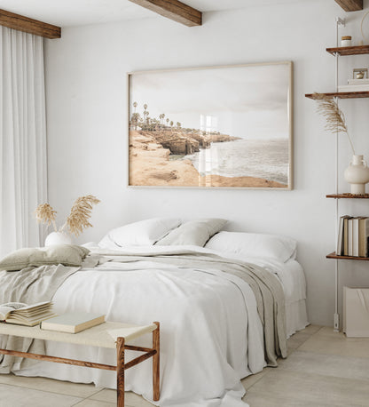 Fine art of Sunset Cliffs, San Diego California horizontal print of hazy high-angle landscape beach photography captures a light blue ocean meeting tall tan, brown cliffs rise as iconic coastal scenery. Photograph in minimalist mock up.