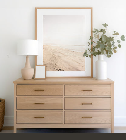Framed fine art photograph of beige sand and white waves at Solana Beach above a dresser