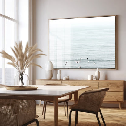 Horizontal surf art showing multiple surfers waiting in the calm ocean water for waves, with a hazy Southern California coastline in the distance. This minimalist surf print captures authentic surf vibes. Photograph in minimalist mock up.