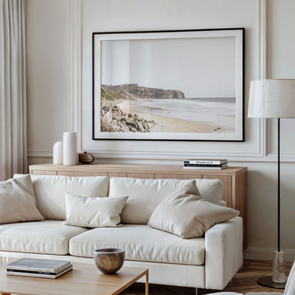 Minimalist ocean print of ocean waves with beach goers in the distance and large  sandy cliffs in the distance overlooking the seascape. Photograph in minimalist mock up.