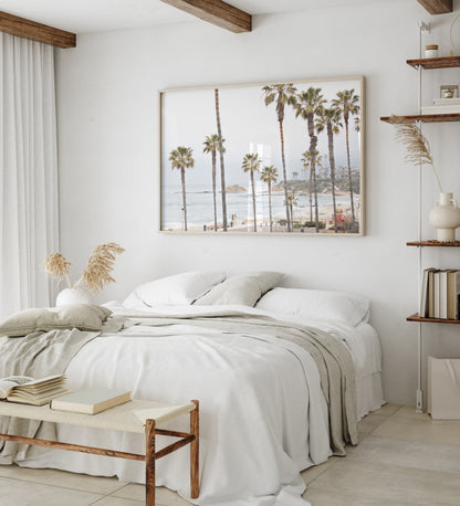Horizontal coastal photography of a beachscape at Laguna Beach, California, beach art print featuring palm trees and a clear blue sky with a few clouds over a beach scene. Photograph in minimalist mock up.