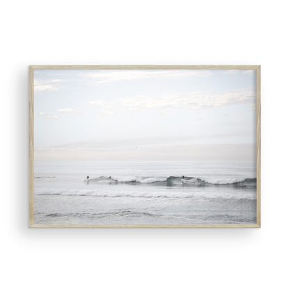Horizontal minimalist ocean art with a close-up blue waves print of water, featuring subtle ripples and soft textures, ideal as a neutral ocean print, surfers in the waves. Photograph in minimalist mock up.