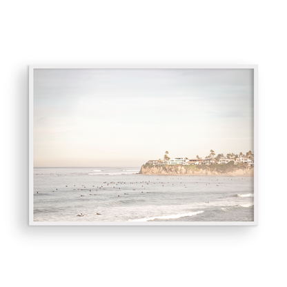 Landscape San Diego beach print of Tourmaline Beach, Pacific Beach, San Diego, showing a large group of surfers in the water near a residential cliff. This surf vibes print captures the local surf scene. Photograph in minimalist mock up.